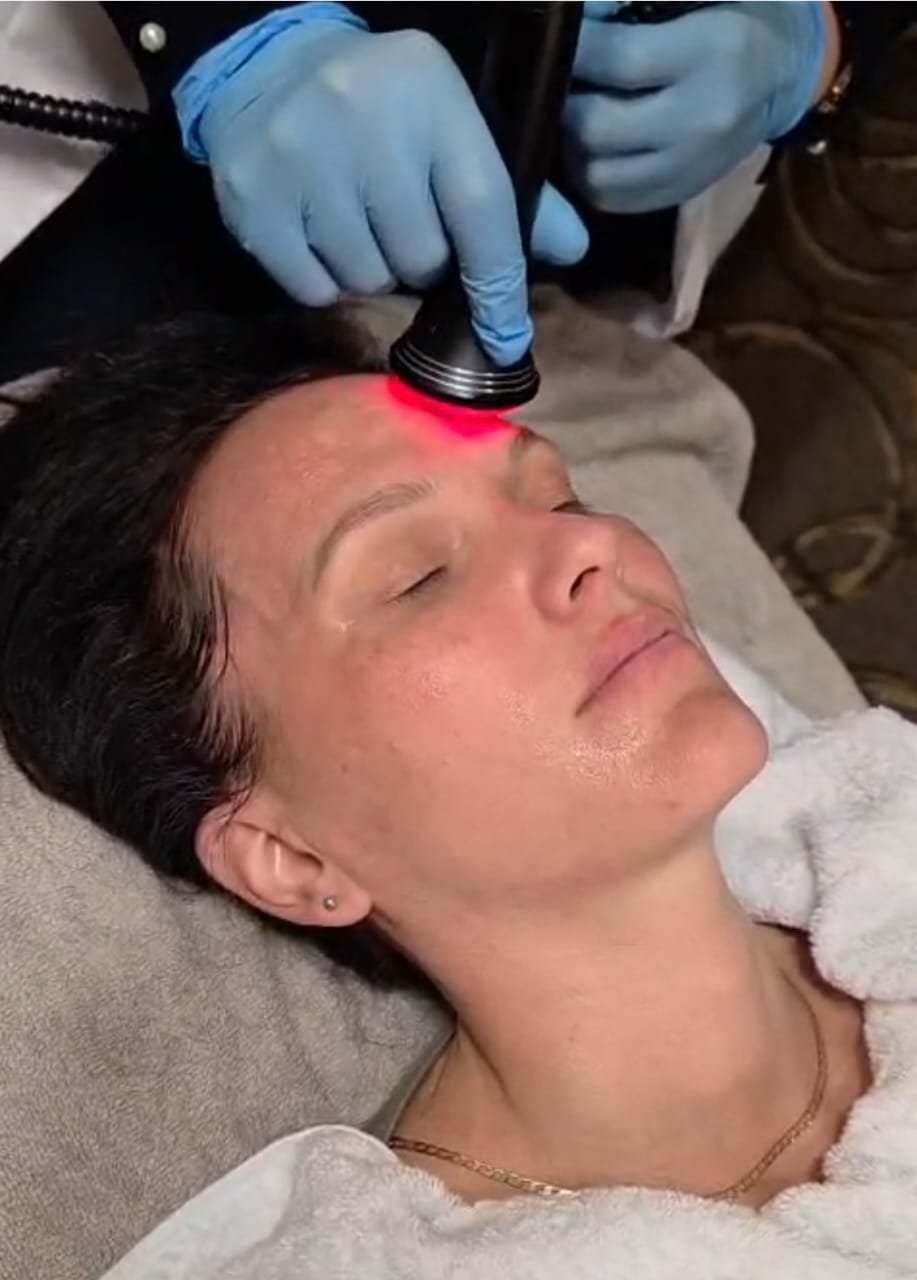A client receiving red LED light therapy on the face