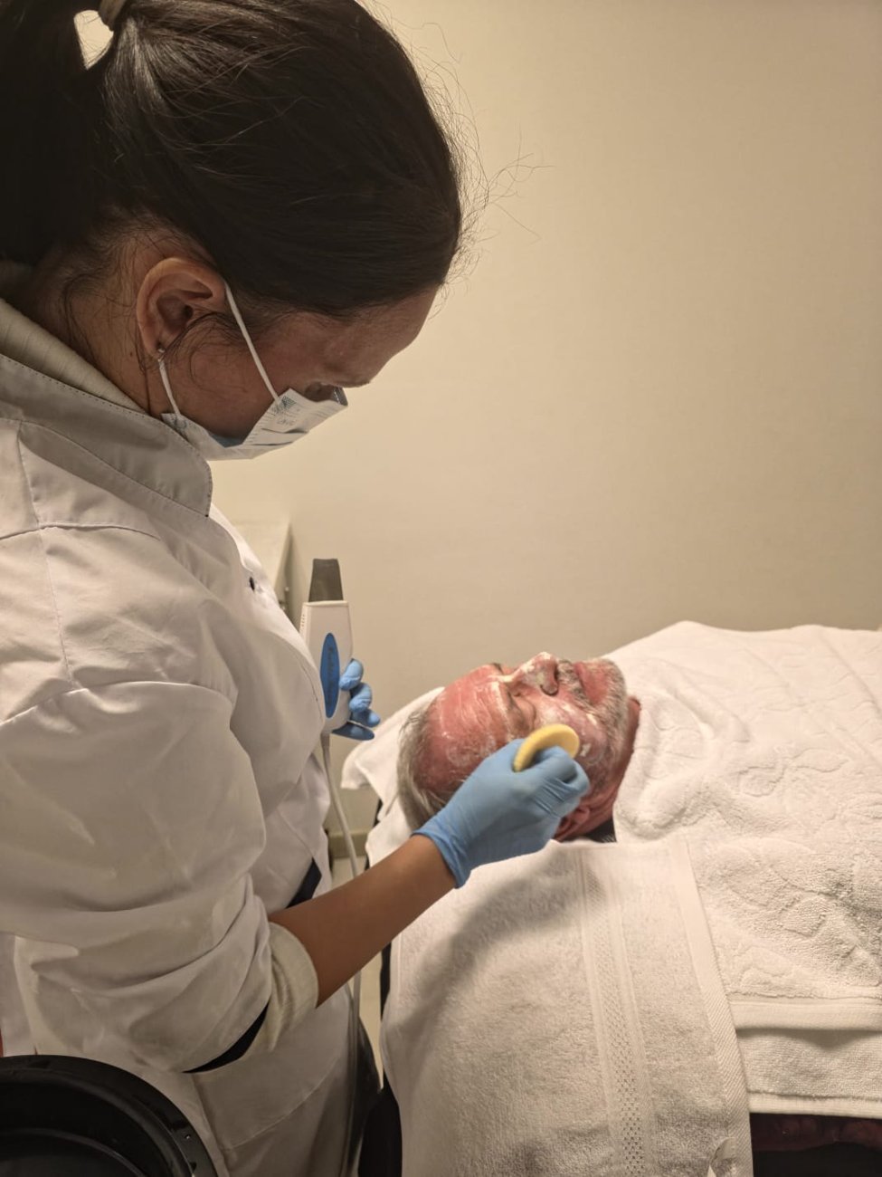 A therapist applying a facial treatment to a client